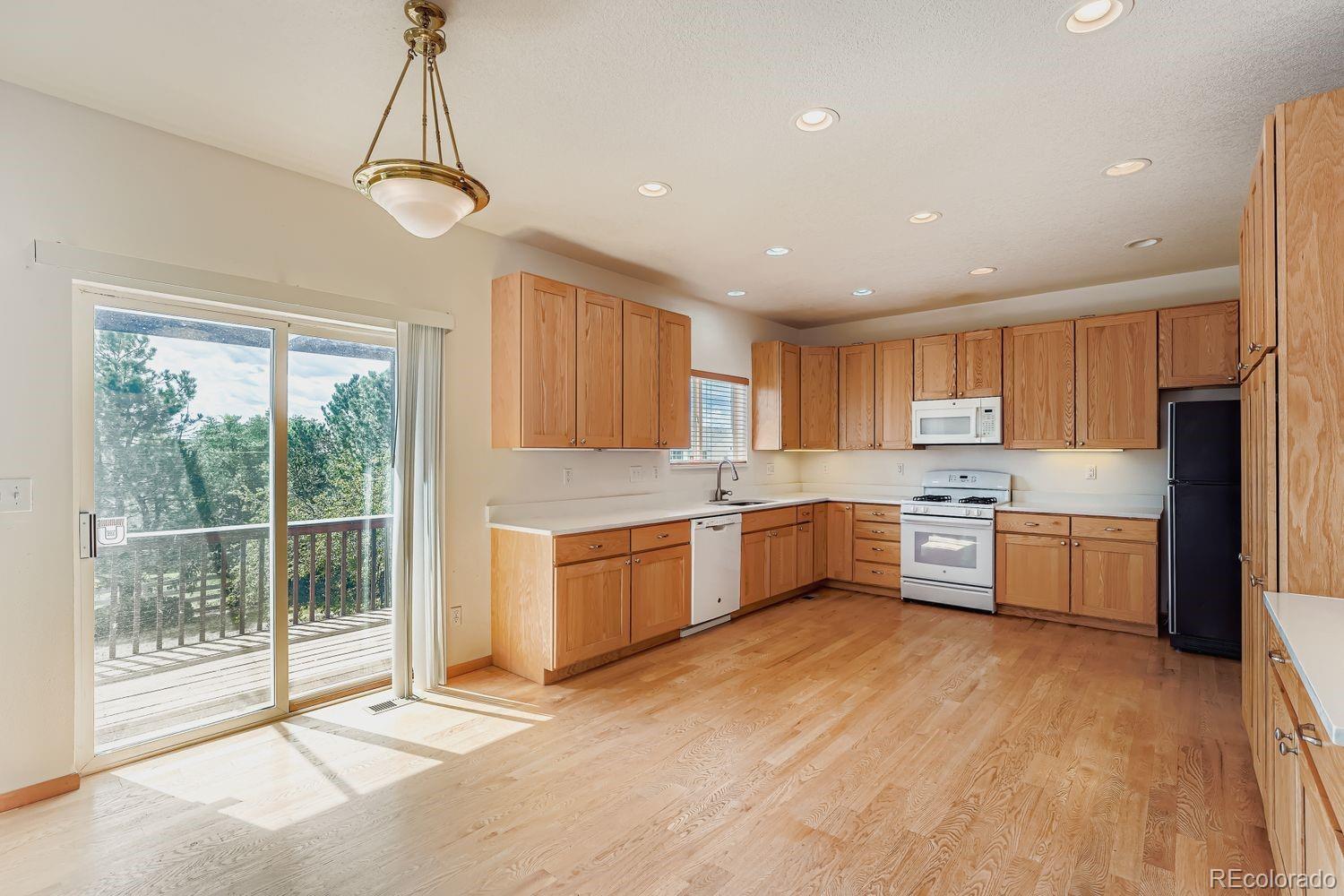 20758 East Maplewood Lane Centennial, CO 80016 - Photo 7 of 29 a large kitchen with a large window and stainless steel appliances