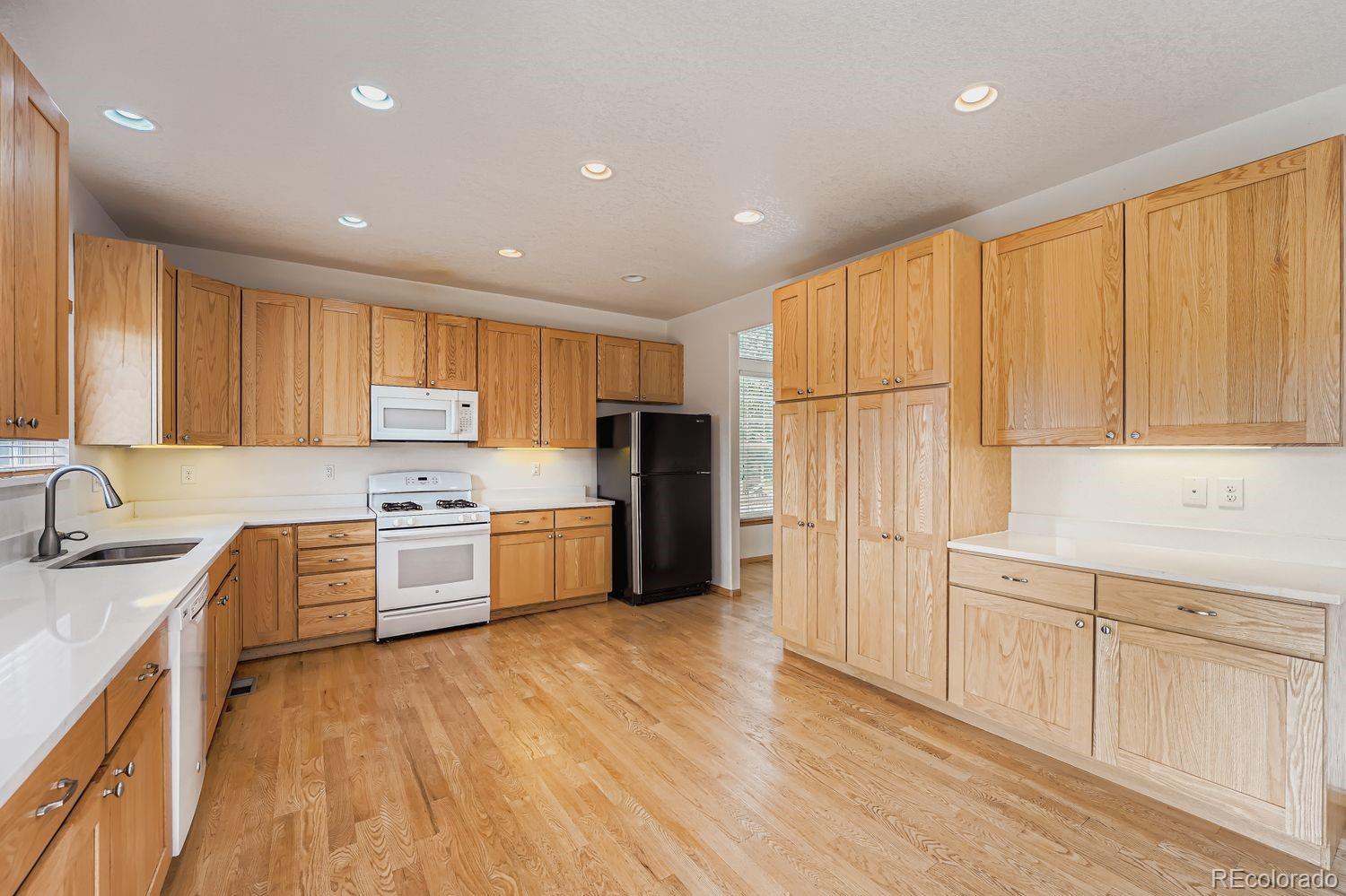20758 East Maplewood Lane Centennial, CO 80016 - Photo 10 of 29 a kitchen with granite countertop a refrigerator stove top oven and sink