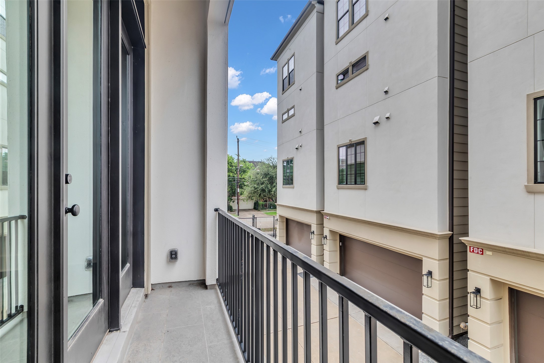 2716 Baldwin Street Houston, TX 77006 - Photo 14 of 26 This balcony, accessible from the living area, provides a clear view of the surrounding neighborhood and nearby homes.