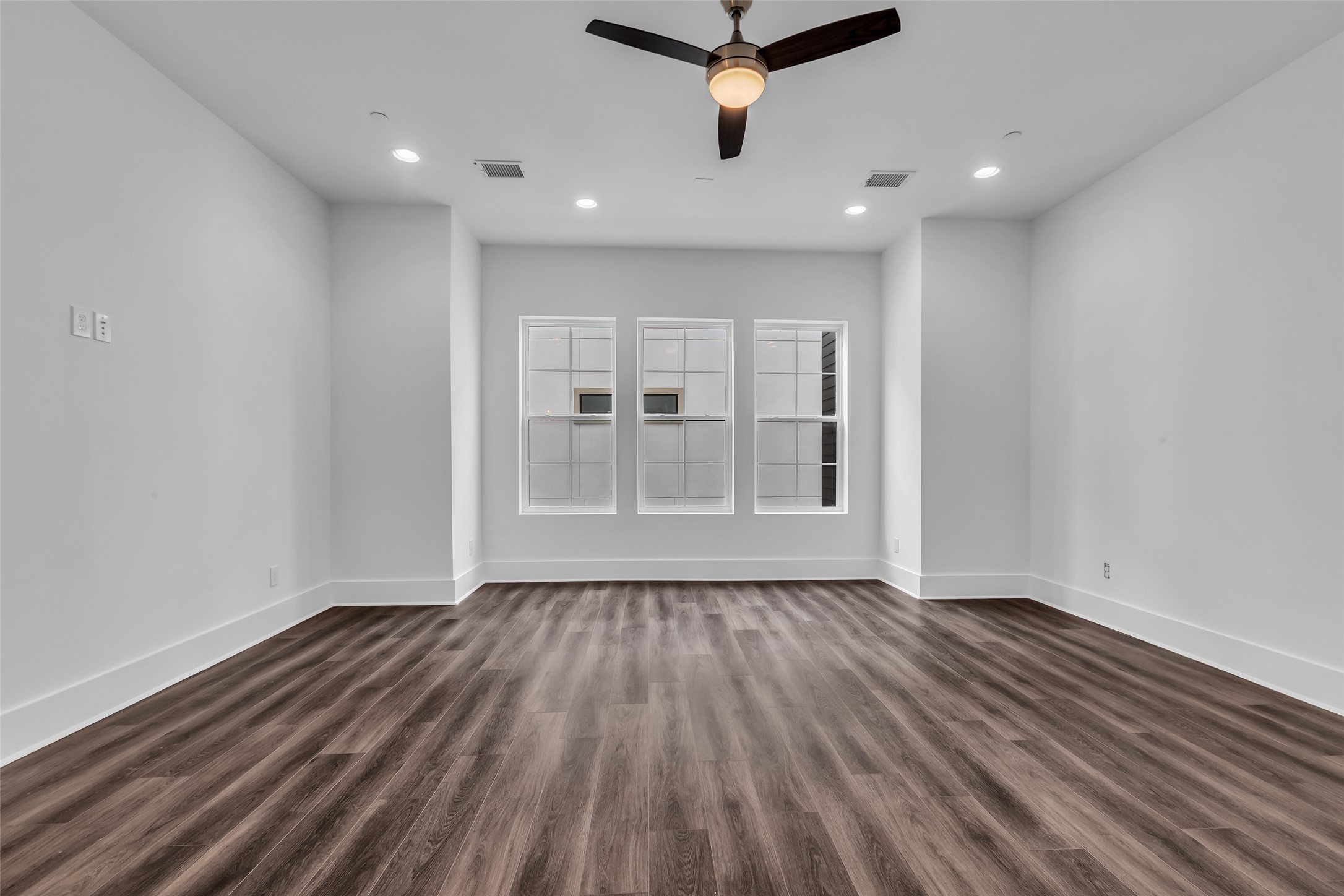 2716 Baldwin Street Houston, TX 77006 - Photo 15 of 26 The primary bedroom on the third floor features vinyl plank flooring and large windows that let in plenty of natural light. It's a versatile space that can be arranged to fit your style and needs.