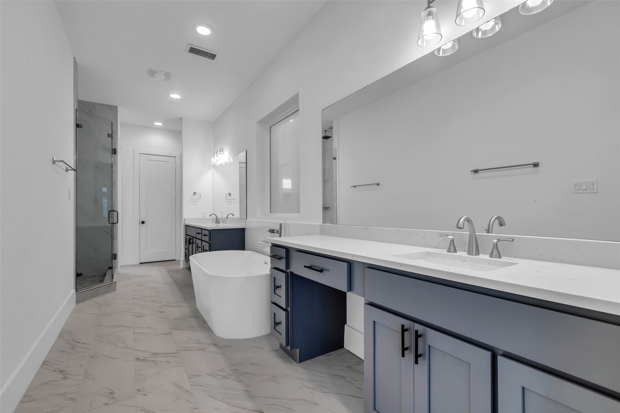 2716 Baldwin Street Houston, TX 77006 - Photo 16 of 26 The primary bathroom is generously sized and includes dual sinks, a bathtub, a separate shower area, and ample drawer space for storage.