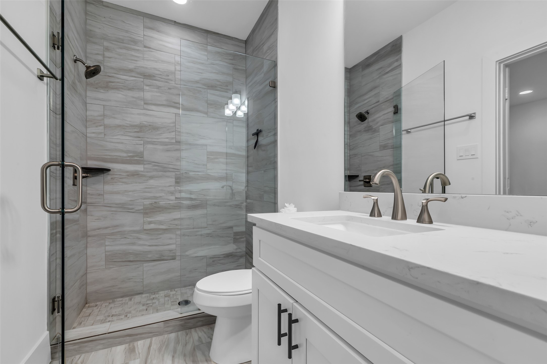 2716 Baldwin Street Houston, TX 77006 - Photo 3 of 26 This first-floor bathroom includes a glass-enclosed shower and contemporary finishes. Just beside it, there’s a convenient walk-in closet (not shown in the photo).