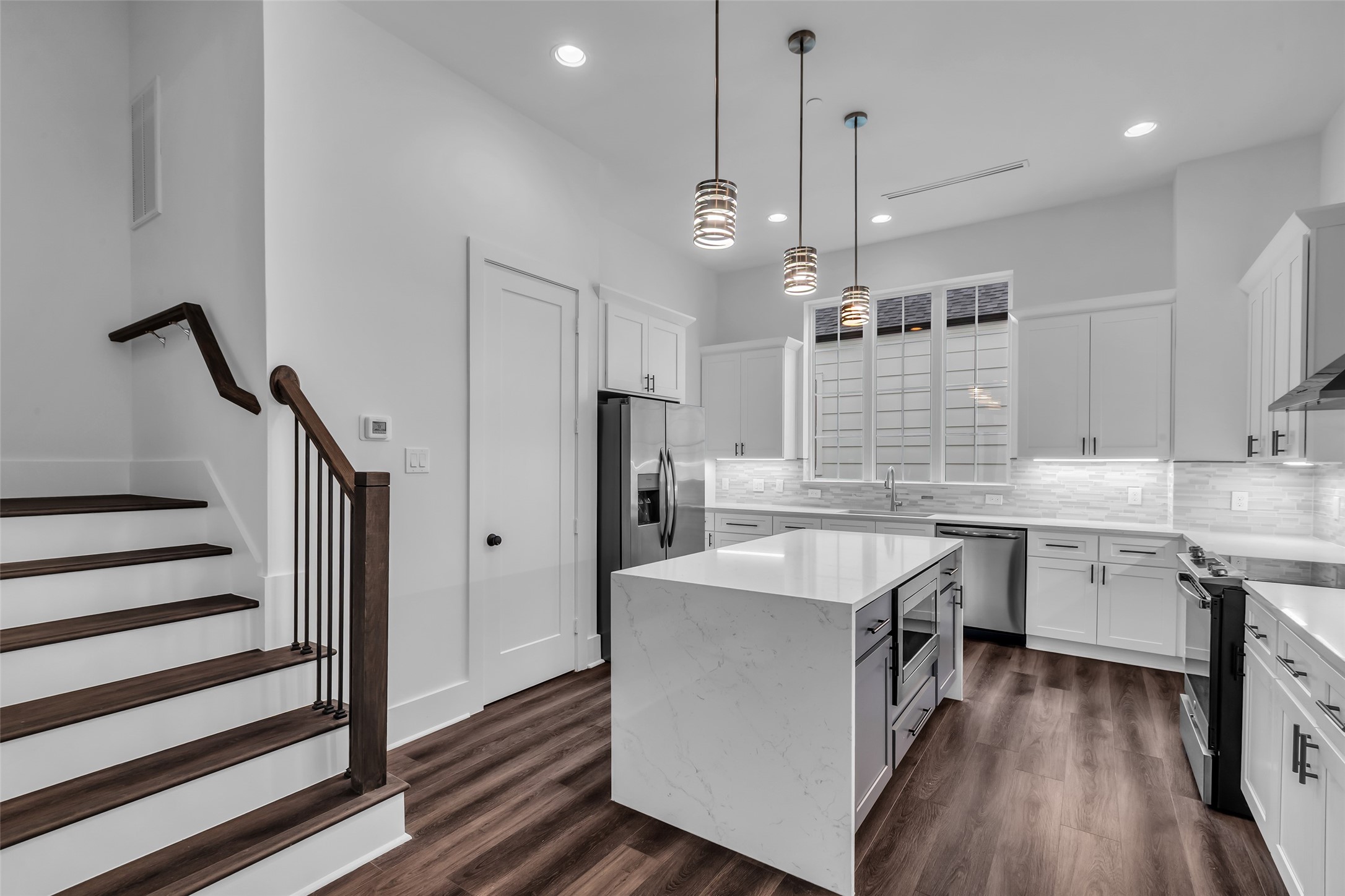 2716 Baldwin Street Houston, TX 77006 - Photo 8 of 26 From the kitchen, a staircase leads directly to the third floor, connecting the main living space with the upper level.