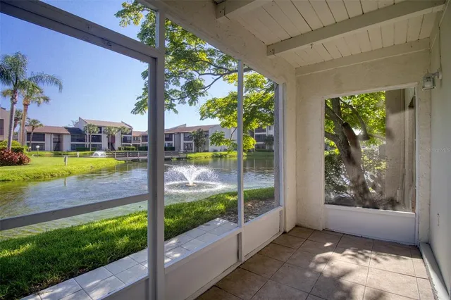 a view of swimming pool with lawn chairs and floor to ceiling window and wooden fence