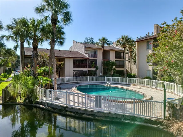 a view of a house with pool and chairs