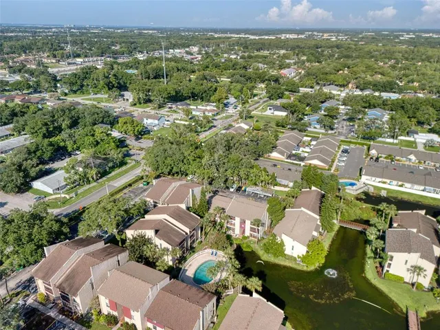an aerial view of residential houses with outdoor space and trees