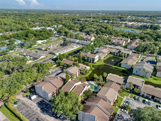 an aerial view of residential houses with outdoor space and trees