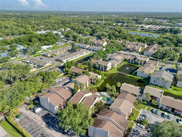 an aerial view of residential houses with outdoor space and trees