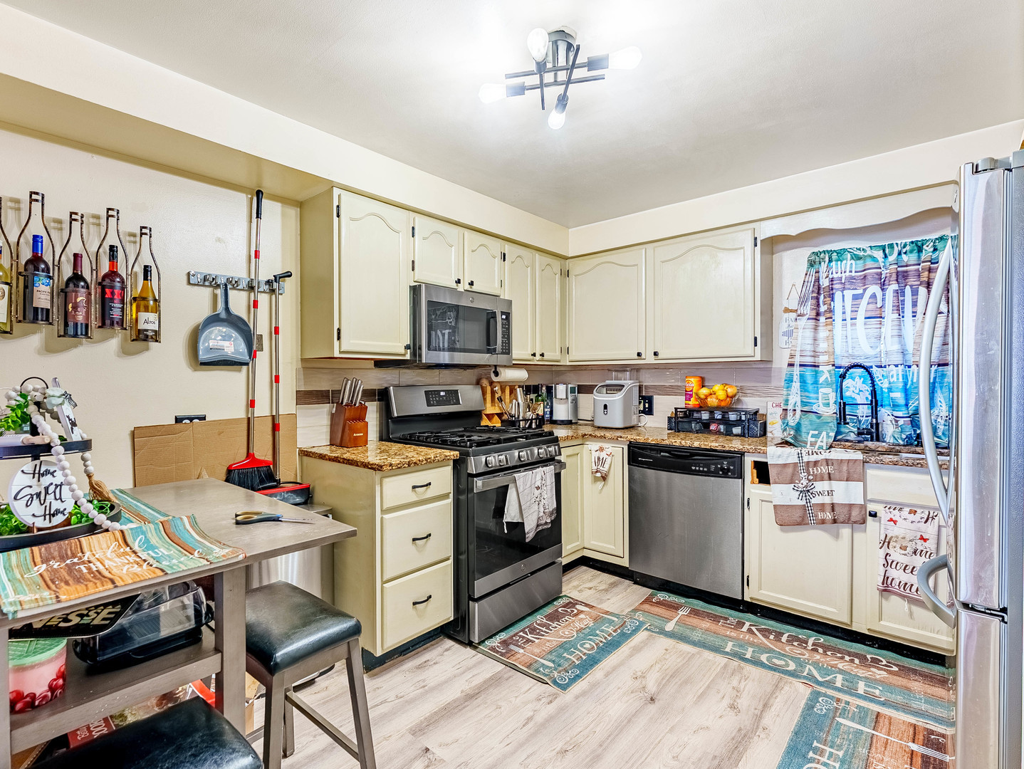 6337 Roosevelt Road, Unit 309 Berwyn, IL 60402 - Photo 9 of 27 a kitchen with stainless steel appliances kitchen island granite countertop a stove top oven a sink a dining table and chairs with wooden floor