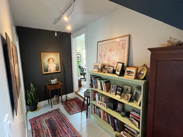 a view of a hallway with wooden floor and stairs