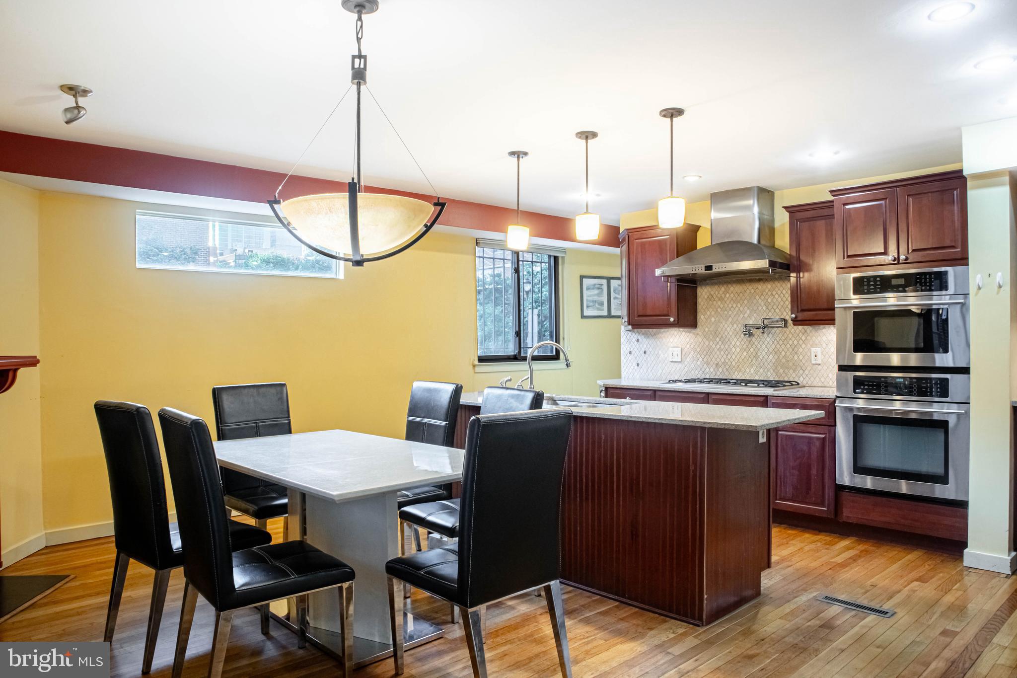 906 Locust Street Philadelphia, PA 19107 - Photo 36 of 46 a kitchen with stainless steel appliances granite countertop a table chairs and a refrigerator