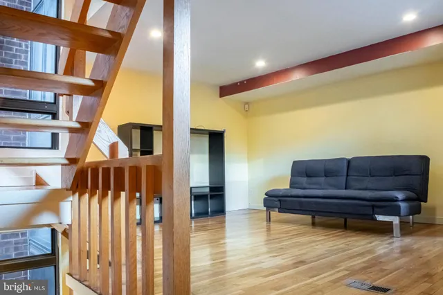 a living room with couch and a wooden floor