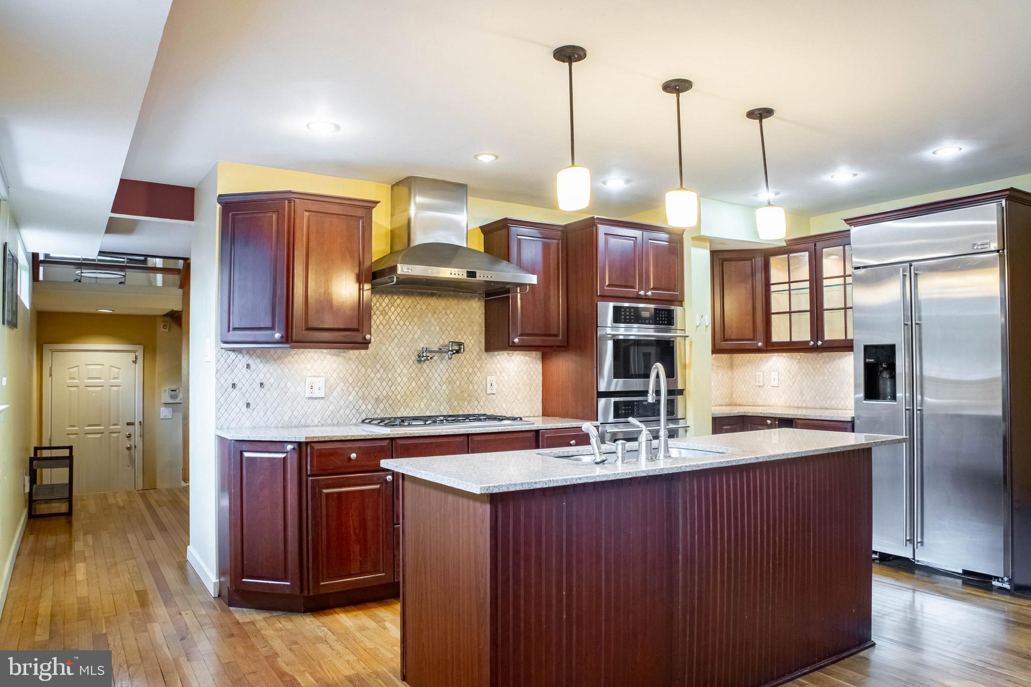906 Locust Street Philadelphia, PA 19107 - Photo 4 of 46 a kitchen with kitchen island granite countertop a large counter space stainless steel appliances and cabinets