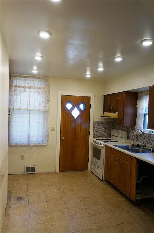 421 Ormsby Avenue Pittsburgh, PA 15210 - Photo 11 of 30 a kitchen with stainless steel appliances granite countertop a stove a sink and a refrigerator