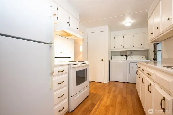 a kitchen with white cabinets and white appliances