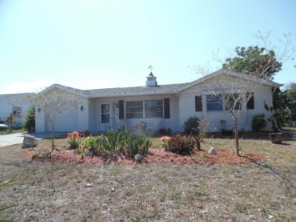a view of a house with a yard and sitting area