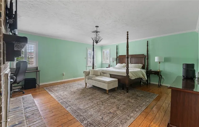 a bedroom with a bed table and chairs