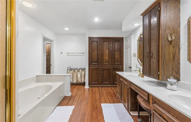 a bathroom with a double vanity sink a mirror and a bathtub