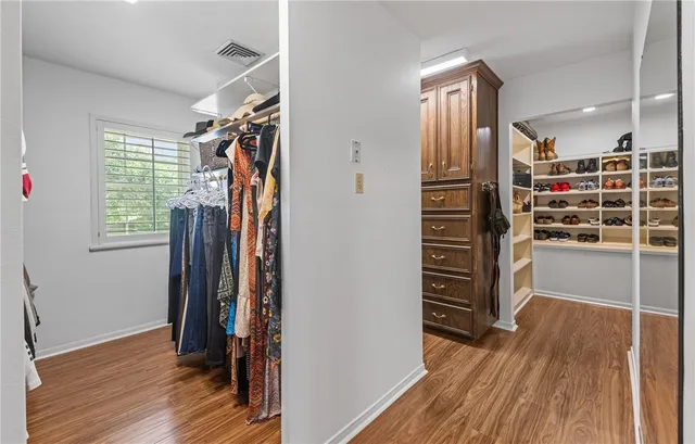 a view of walk in closet with clothes and shoes