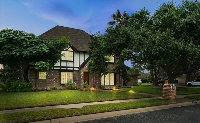 a view of a white house with a big yard and large tree