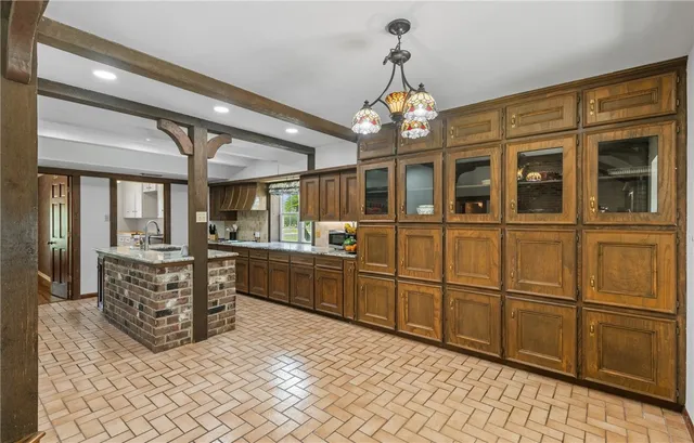 a large kitchen with stainless steel appliances granite countertop a refrigerator and cabinets