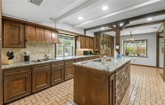 a kitchen with granite countertop sink stove and cabinets