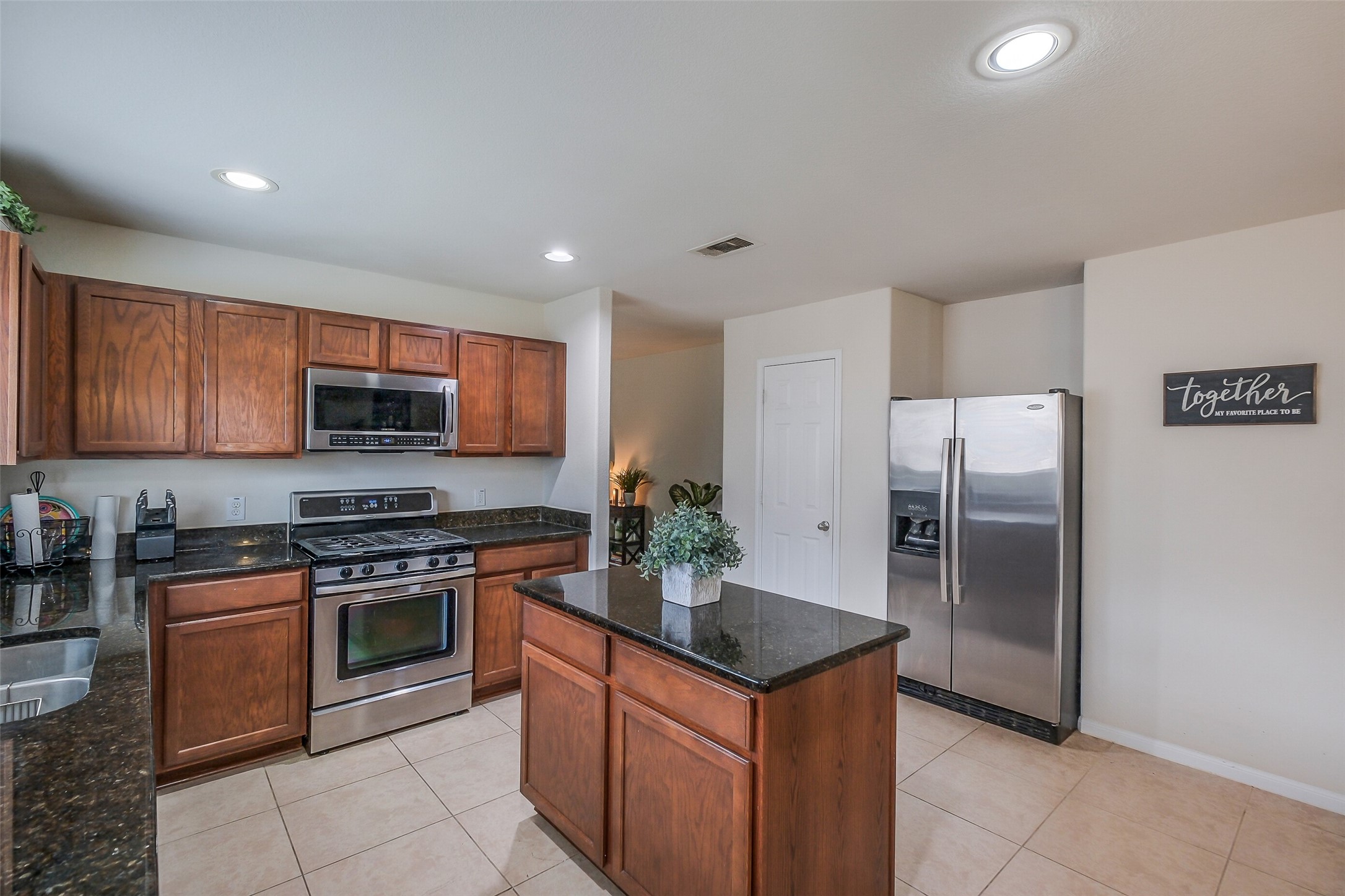1015 Honeysuckle Vine Drive Rosenberg, TX 77469 - Photo 12 of 29 a kitchen with stainless steel appliances granite countertop a stove top oven a refrigerator and a sink