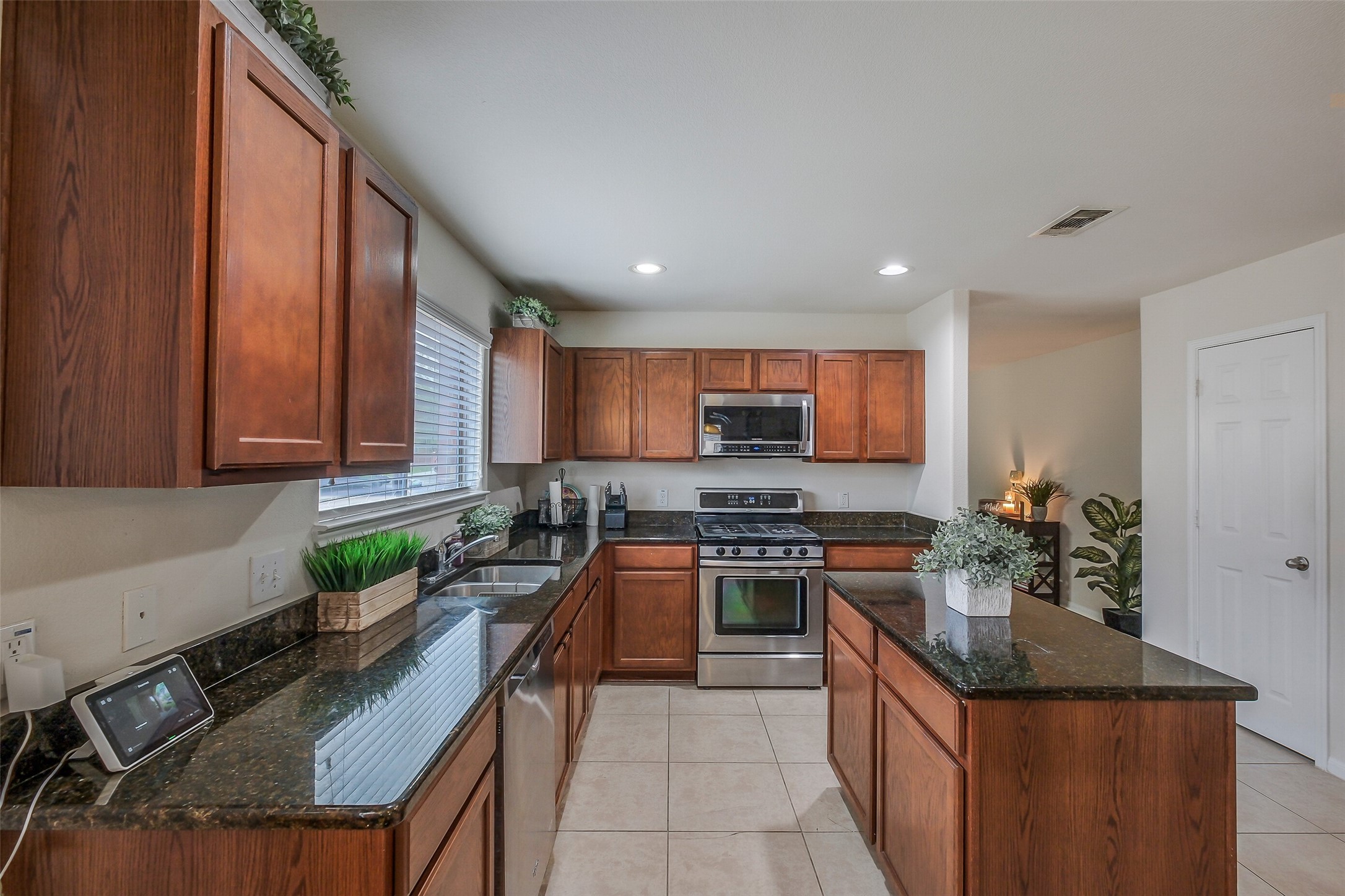 1015 Honeysuckle Vine Drive Rosenberg, TX 77469 - Photo 9 of 29 a kitchen with stainless steel appliances granite countertop a stove top oven a sink a counter space and cabinets
