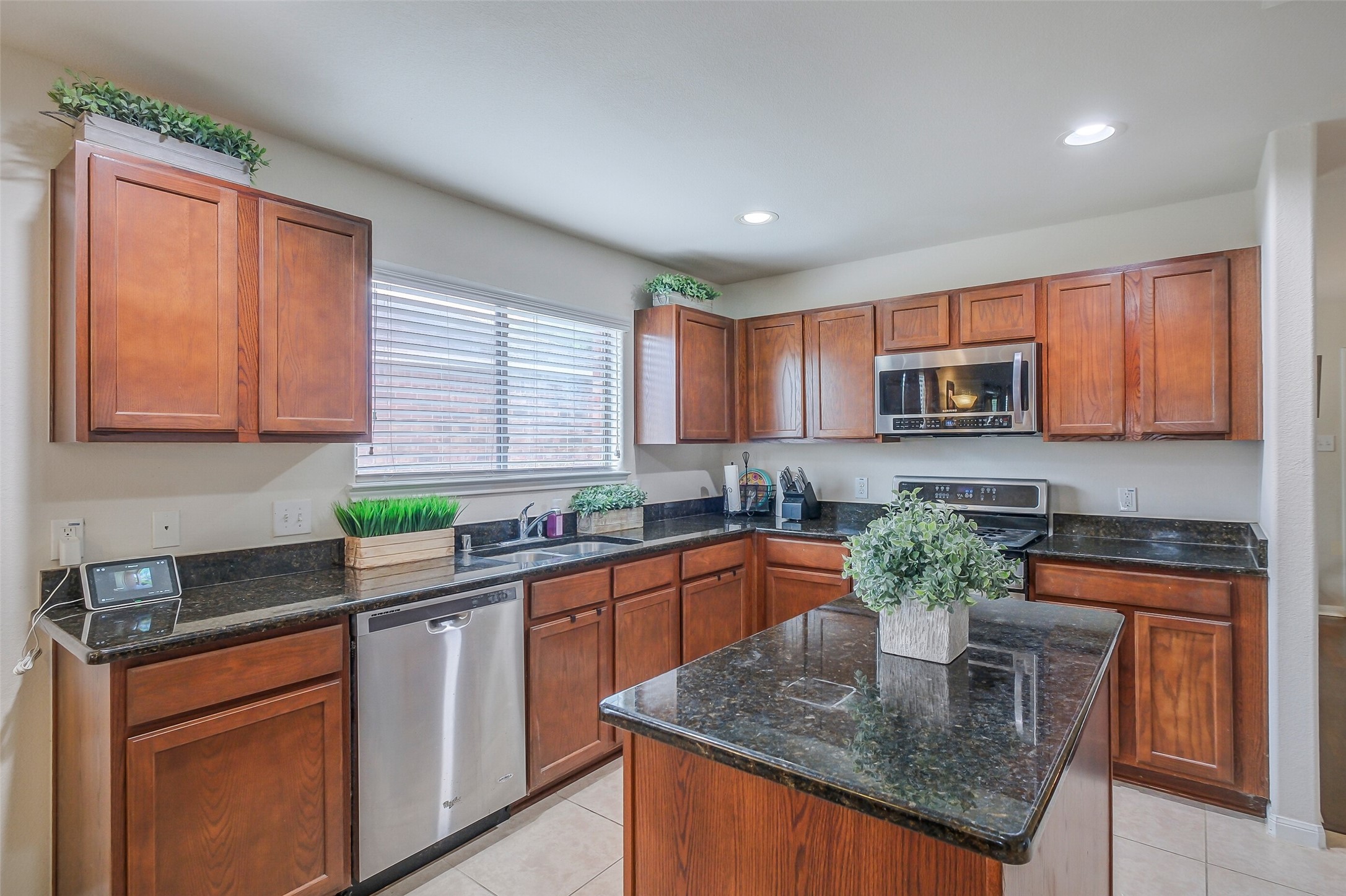 1015 Honeysuckle Vine Drive Rosenberg, TX 77469 - Photo 10 of 29 a kitchen with stainless steel appliances granite countertop sink stove refrigerator and microwave