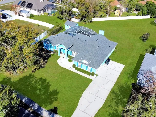 an aerial view of residential houses with outdoor space and parking