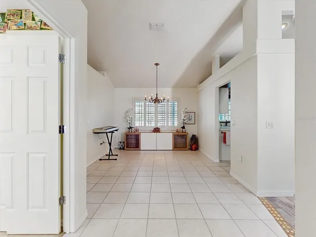 a living room with furniture a chandelier and a view of kitchen