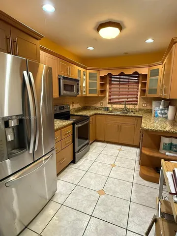 a kitchen with stainless steel appliances granite countertop a refrigerator and a stove top oven