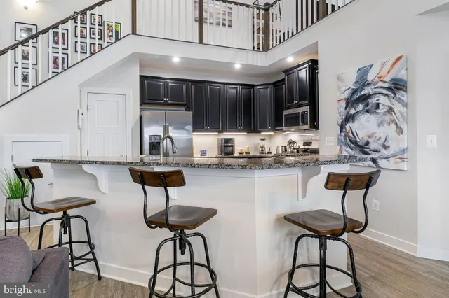 a kitchen with stainless steel appliances granite countertop a refrigerator a sink a stove and cabinets