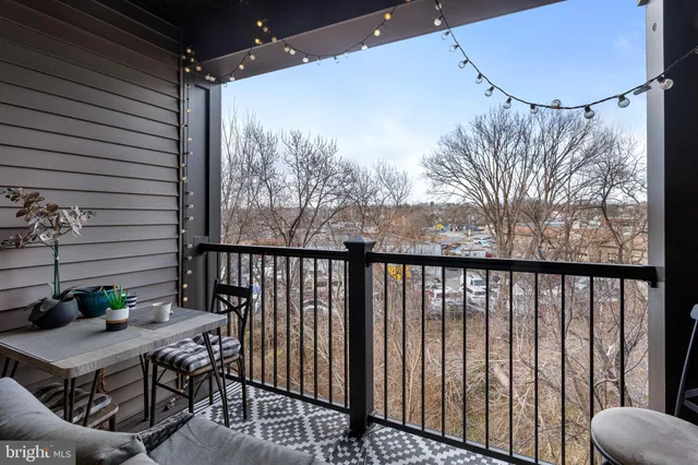 a bedroom with a bed couch tv on desk and a window