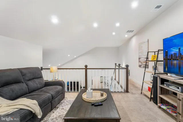 a view of a hallway with a livingroom and a bathroom