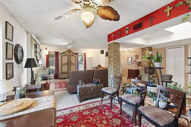 a living room with furniture kitchen view and a large window