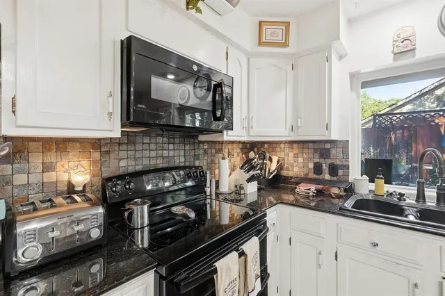 a kitchen with a sink a microwave and cabinets