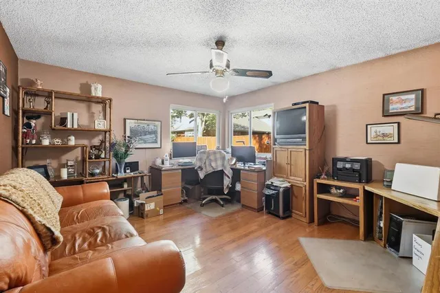 a living room with stainless steel appliances furniture and a kitchen view