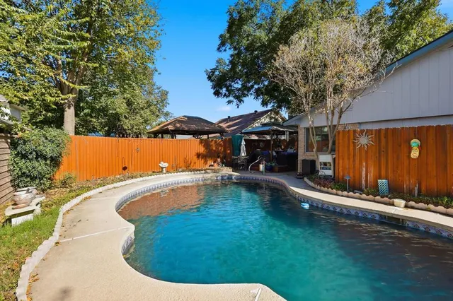 a view of a backyard with couches with wooden fence