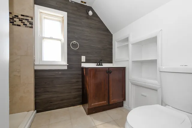 a bathroom with a toilet a sink and window