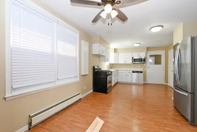 a large kitchen with stainless steel appliances granite countertop a stove top oven a refrigerator a sink and dishwasher