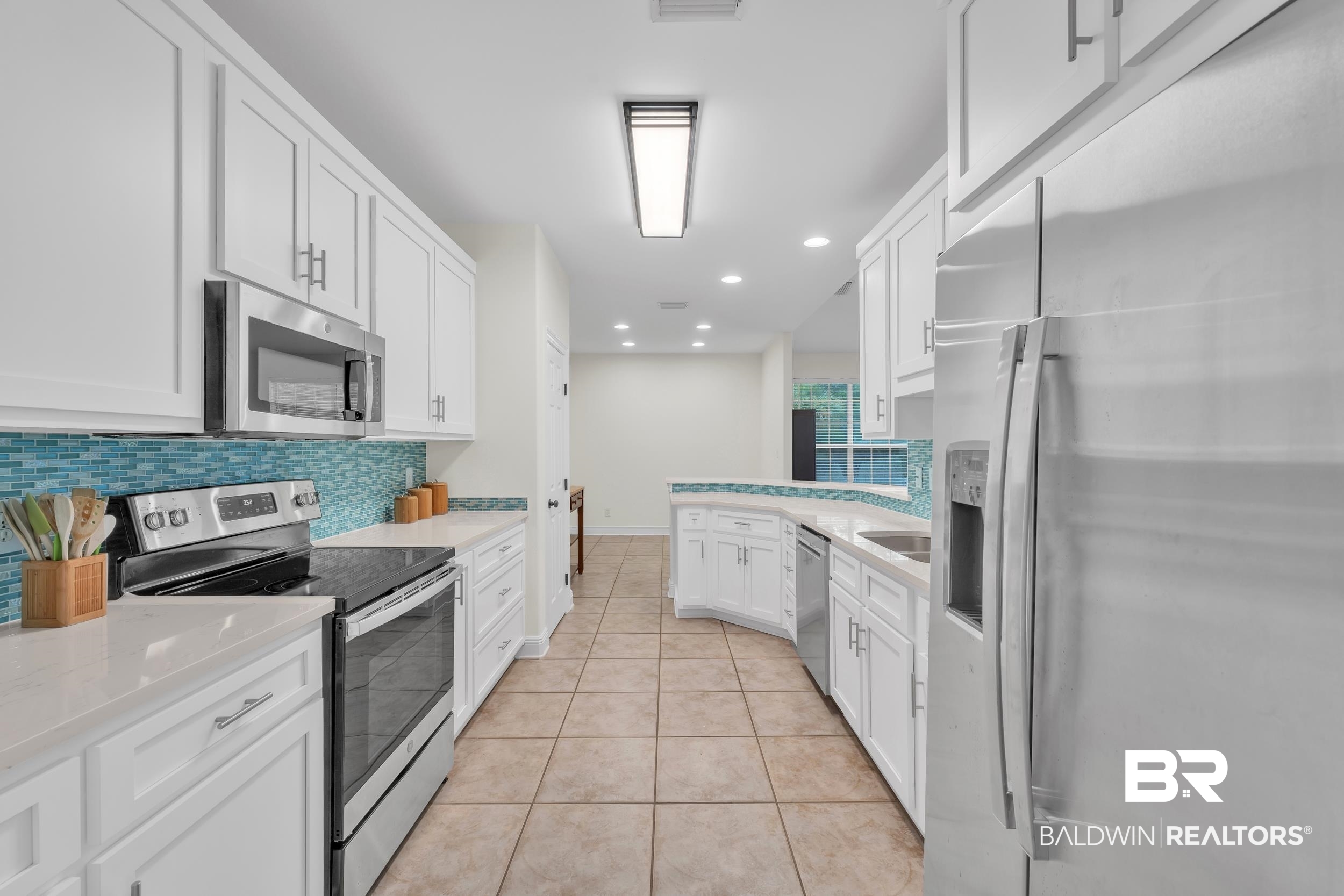4606 Osprey Drive Orange Beach, AL 36561 - Photo 20 of 44 Kitchen with appliances with stainless steel finishes, tasteful backsplash, white cabinets, recessed lighting, and light tile patterned flooring