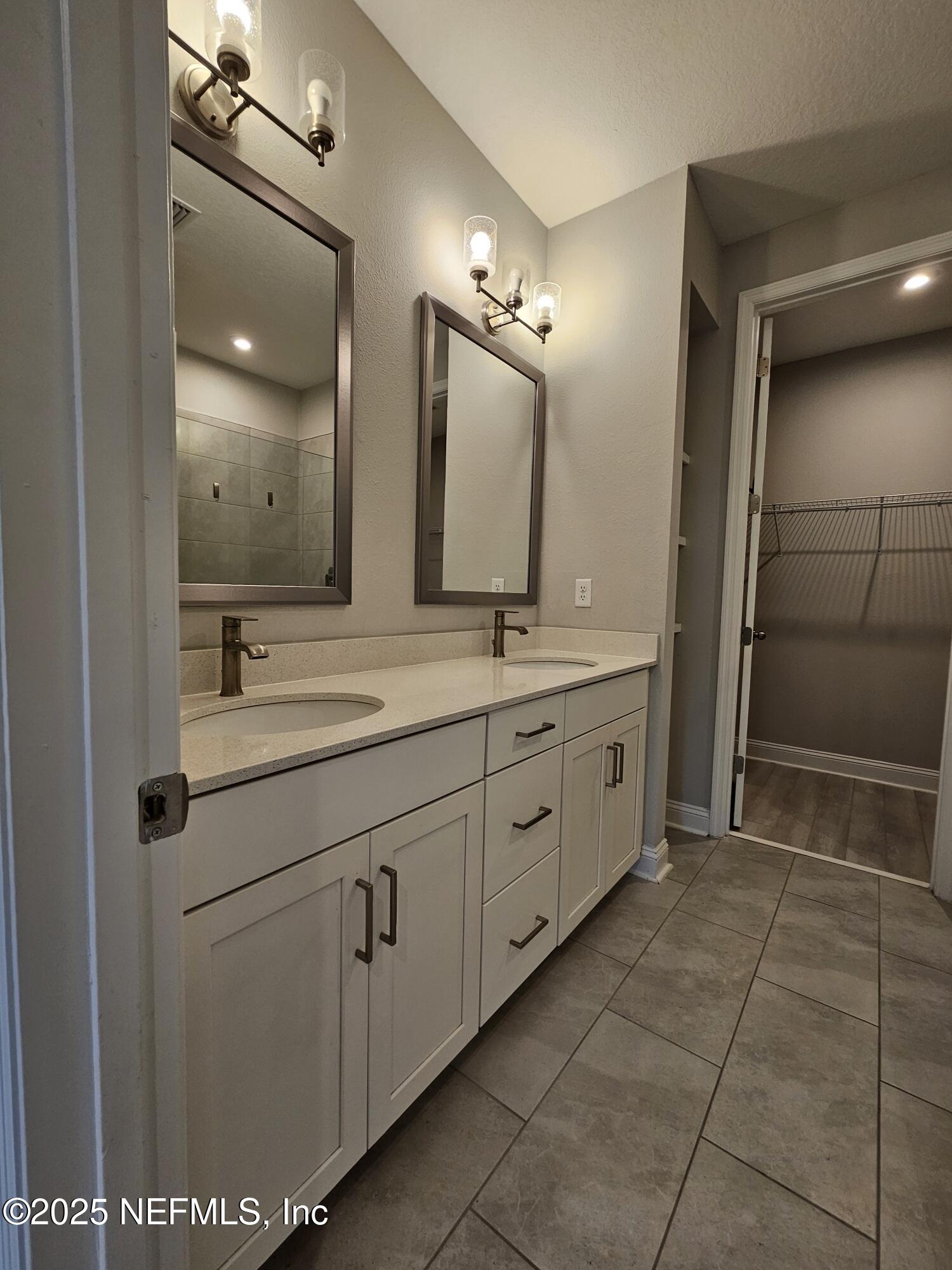 3434 Marsh Reserve Boulevard Jacksonville, FL 32224 - Photo 19 of 39 a spacious bathroom with a double vanity sink a mirror and a shower