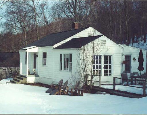 a front view of a house with sitting area and glass windows