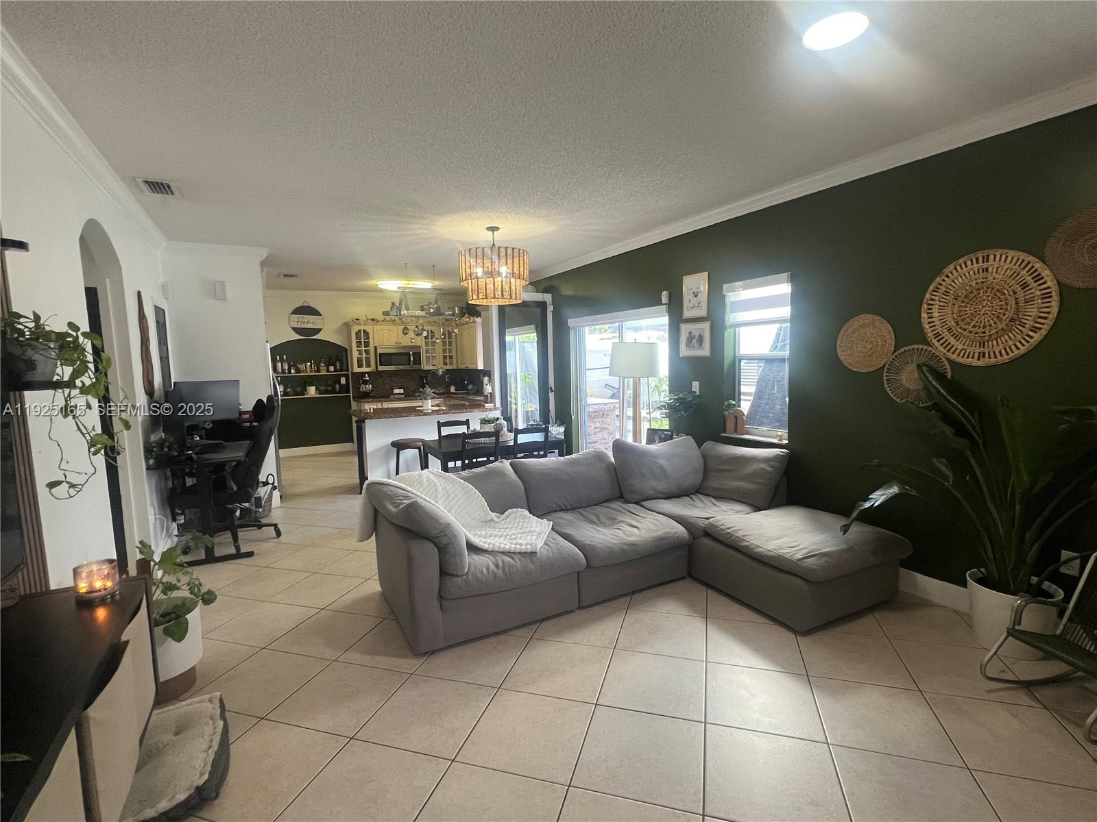 12446 Southwest 198th Street Miami, FL 33177 - Photo 12 of 56 a living room with furniture a fireplace and a projector screen