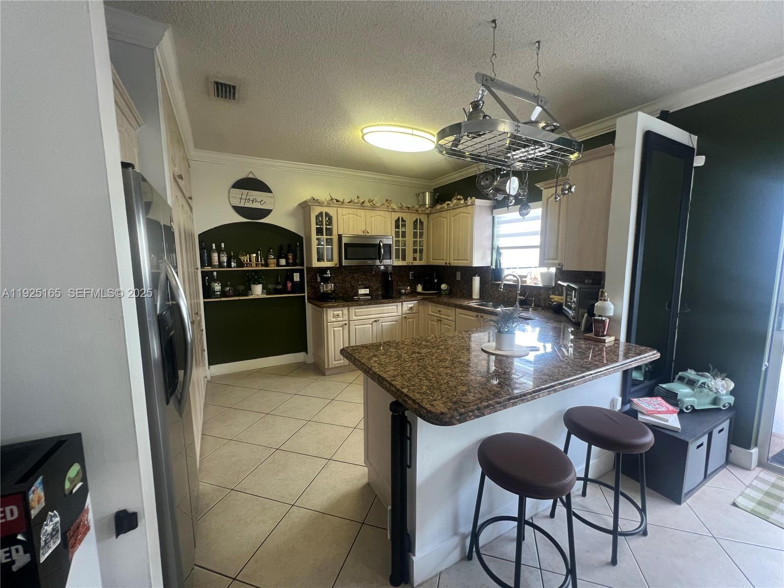 12446 Southwest 198th Street Miami, FL 33177 - Photo 14 of 56 a kitchen with granite countertop a table chairs stove and refrigerator