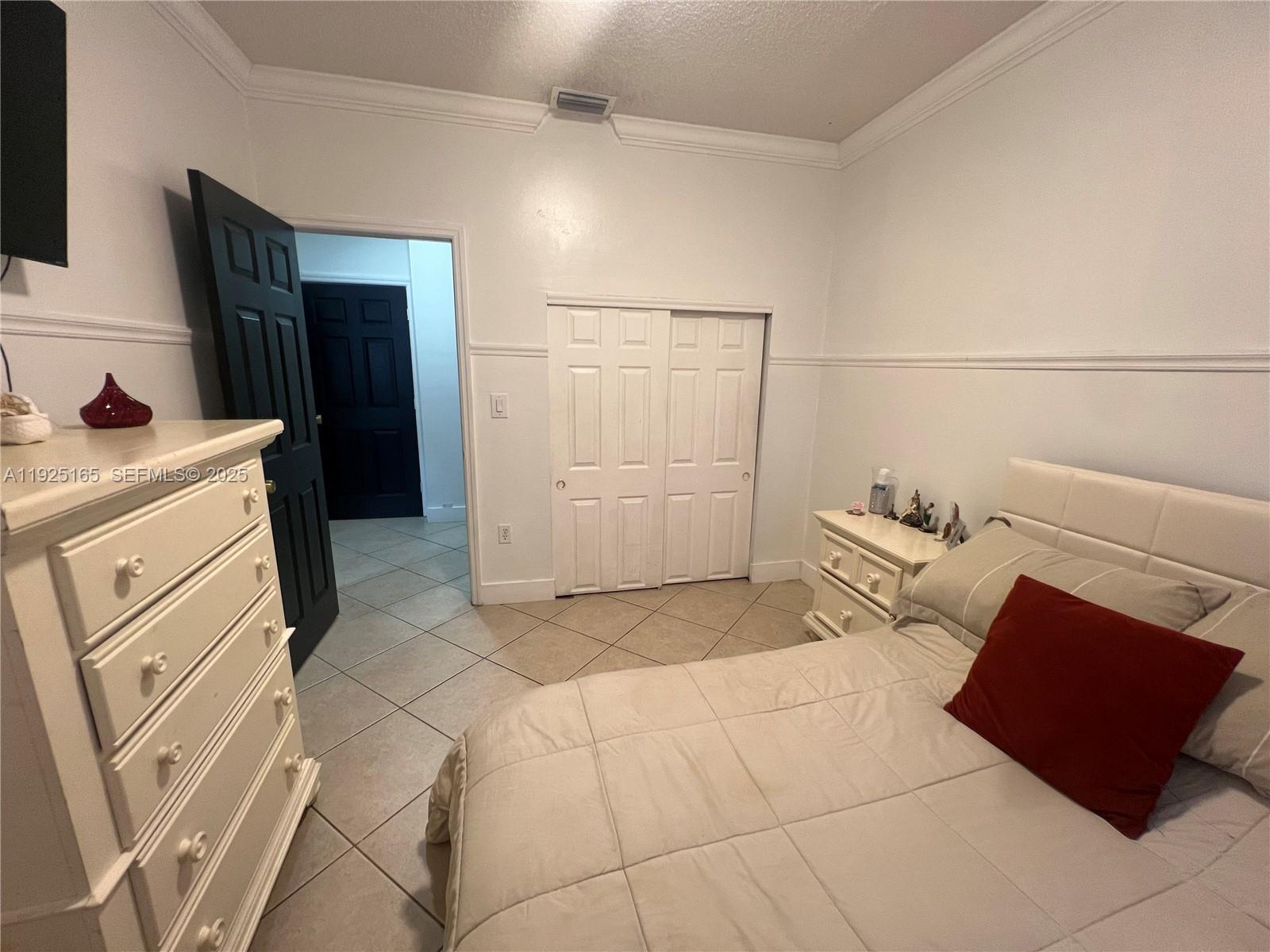 12446 Southwest 198th Street Miami, FL 33177 - Photo 32 of 56 a bedroom with a bed and a mirror