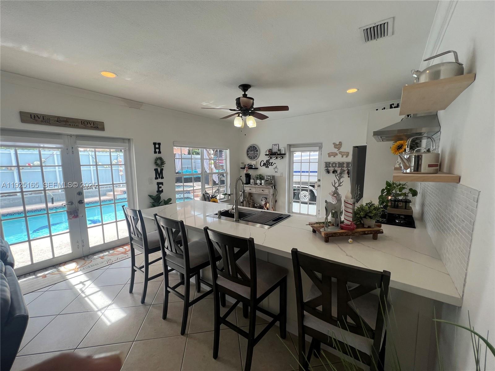 12446 Southwest 198th Street Miami, FL 33177 - Photo 34 of 56 a view of a dining room with furniture and a floor to ceiling window