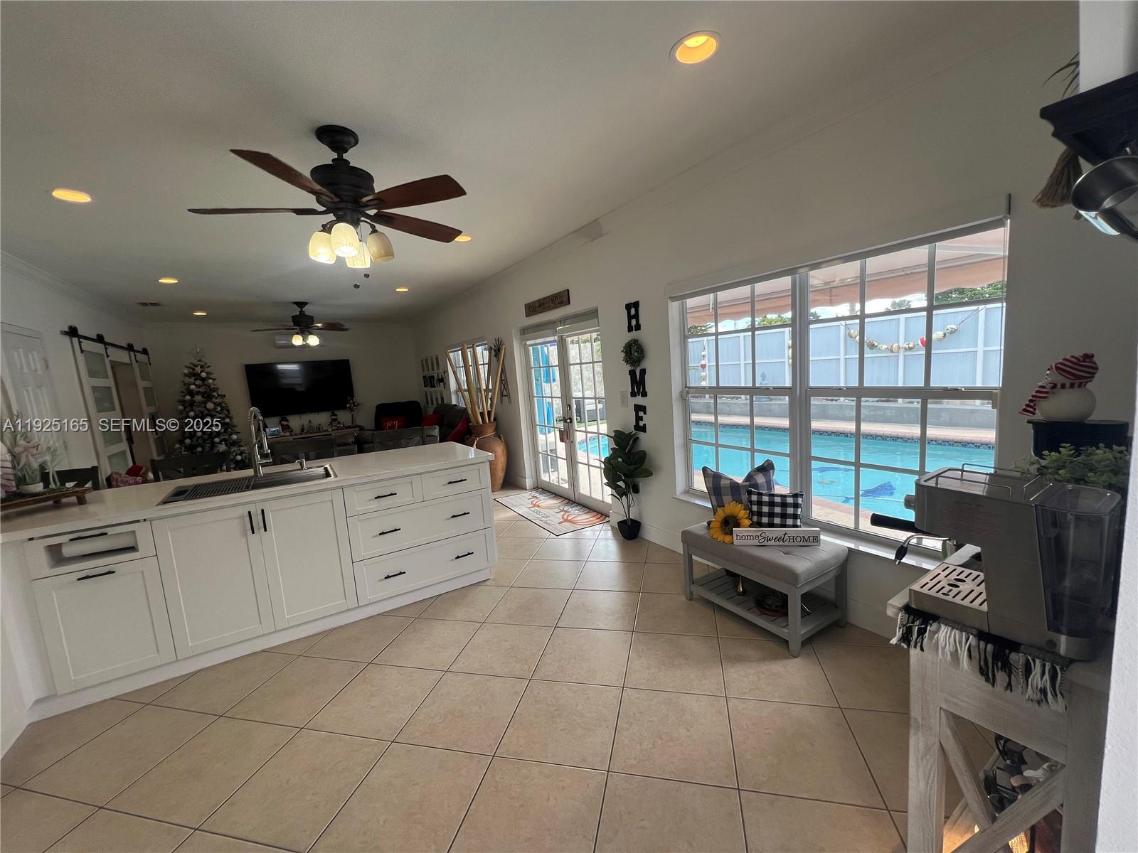 12446 Southwest 198th Street Miami, FL 33177 - Photo 35 of 56 a large white kitchen with granite countertop a stove a sink a dining table and chairs with the potted plants