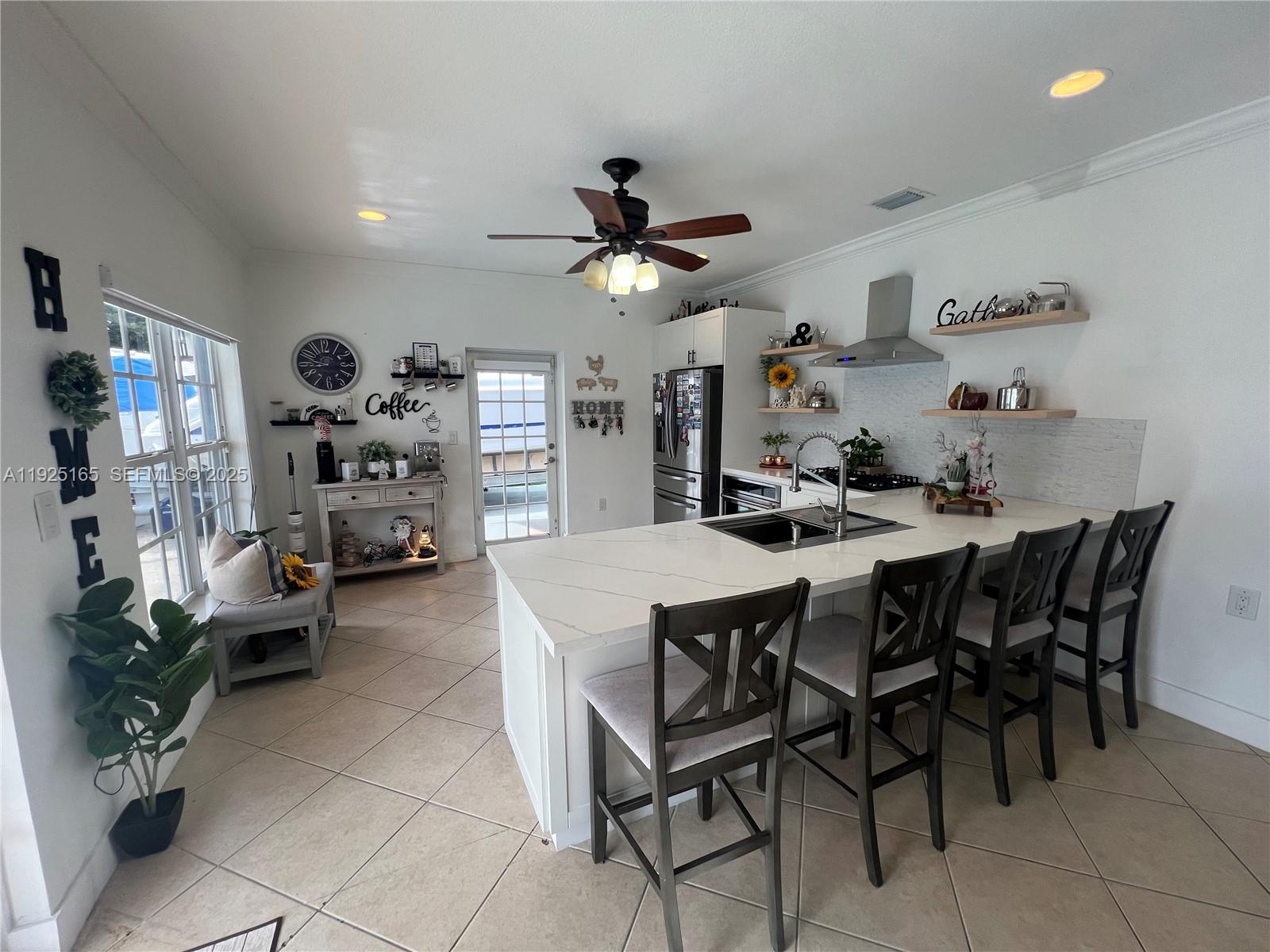 12446 Southwest 198th Street Miami, FL 33177 - Photo 36 of 56 a dining room with furniture and a chandelier fan